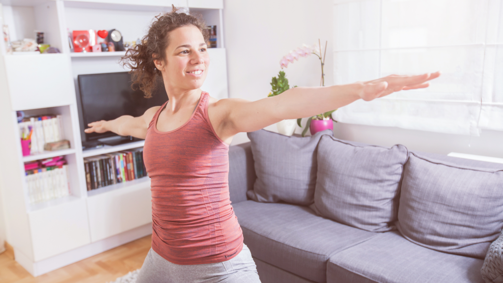 woman stretching in living room as part of her EmbdyHealth telehealth physiotherapy session